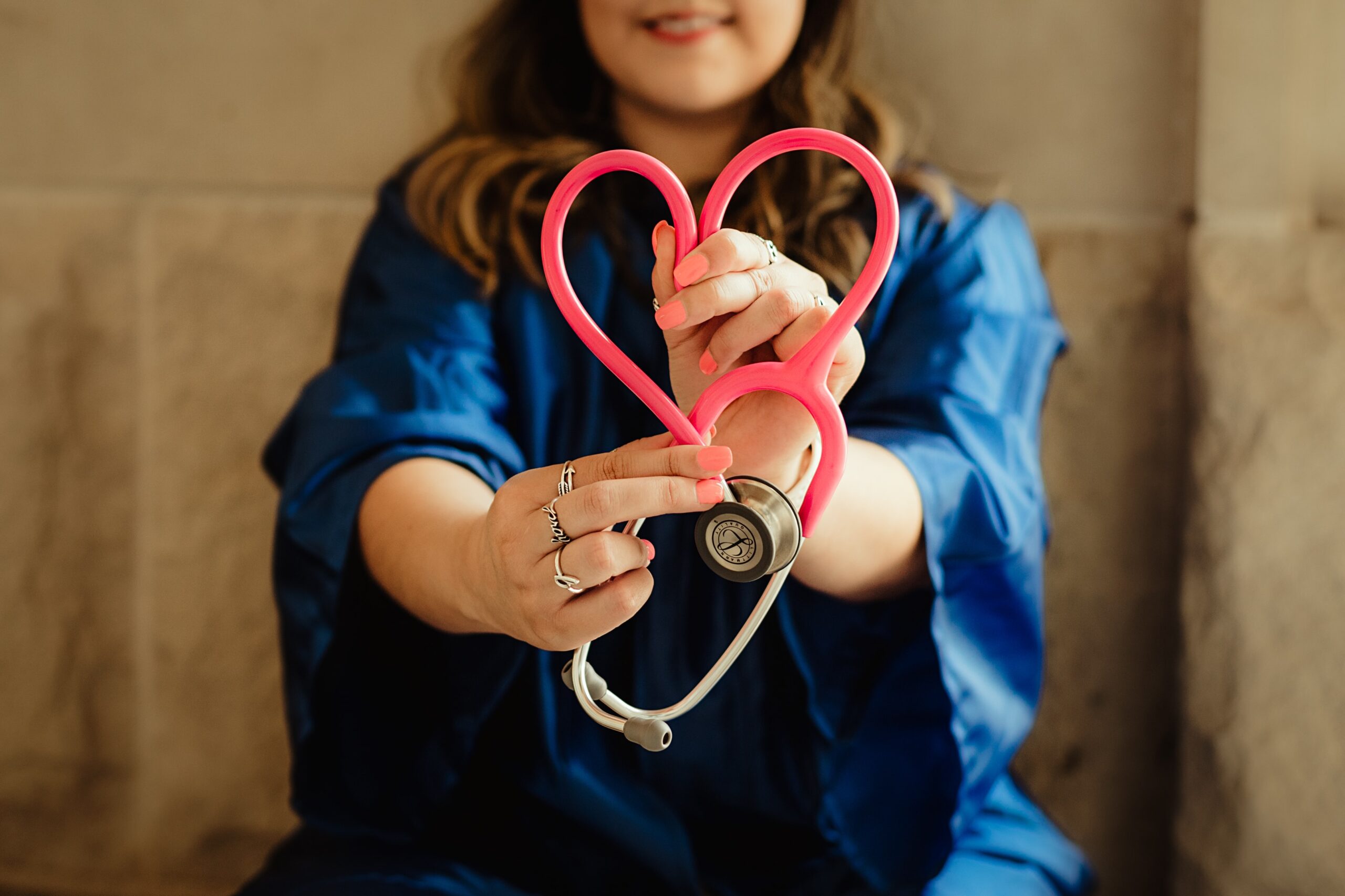 Image shows nurse making heart shape with stethoscope