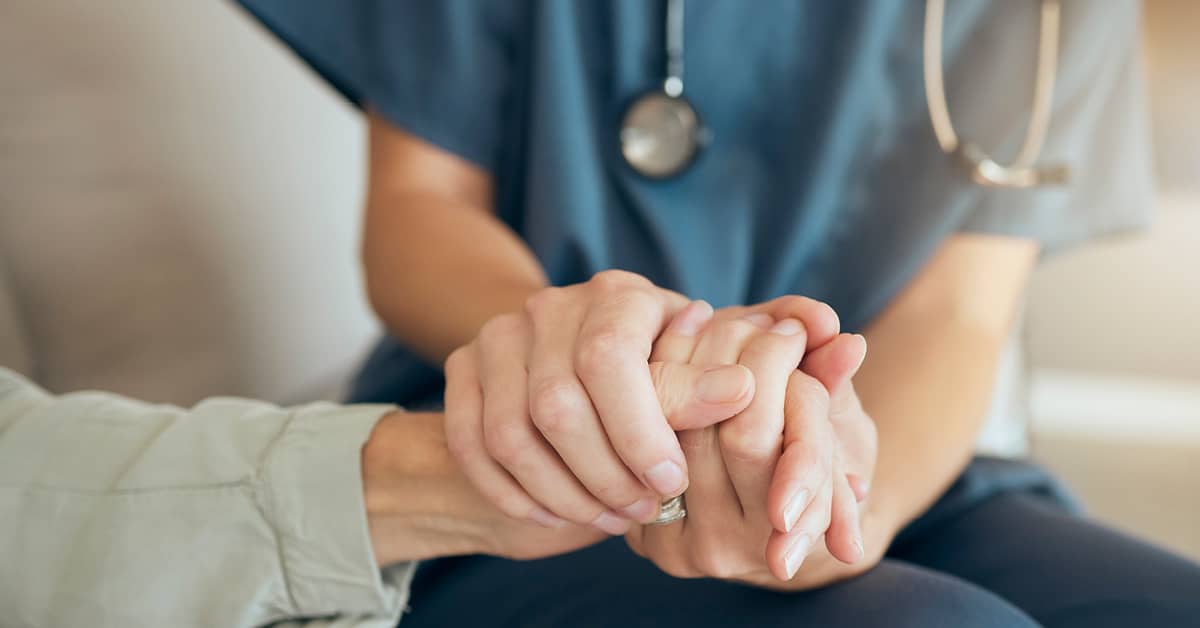 nurse holding patient's hands caringly